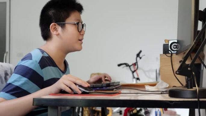 快乐的亚洲游戏玩家男孩戴着防护眼镜，在家玩网络游戏，生活理念。