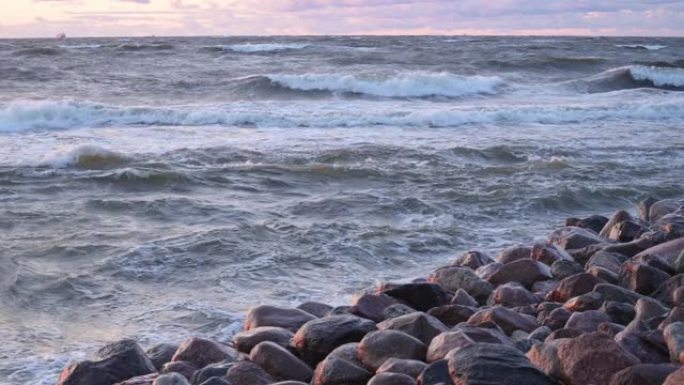 波涛汹涌的岩石海岸线在暴风雨中席卷而来。海浪用泡沫在石头上破裂。