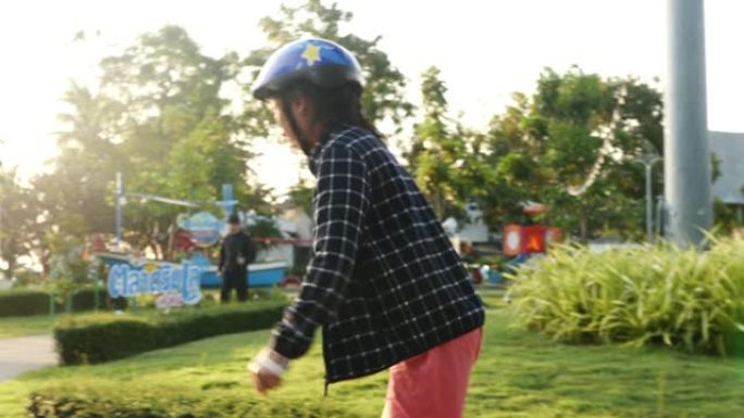亚洲女孩在公园里玩旱冰鞋，早上有阳光，有防护装备，生活理念。