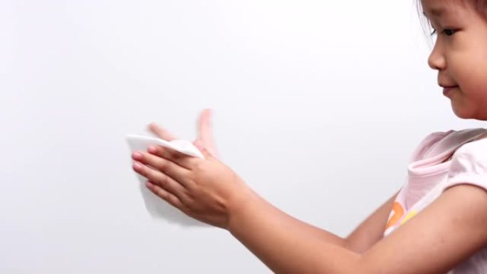 一个亚洲小女孩用白色软组织纸或湿巾清洁双手，以防止冠状病毒新型冠状病毒肺炎病毒感染。医疗保健和医疗概