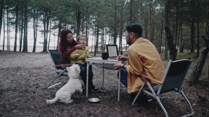 亚洲家庭围坐在野营桌旁