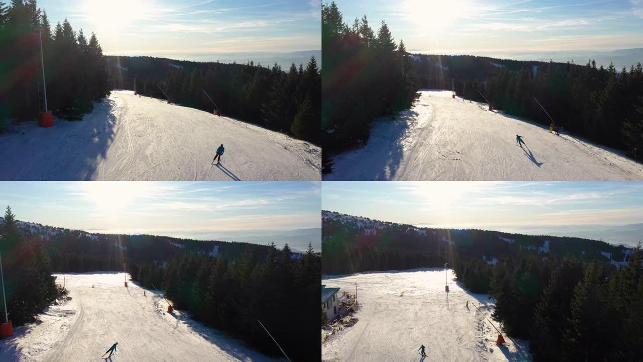 男子在晴天滑雪时，无人驾驶飞机飞越滑雪坡