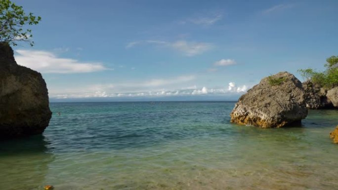 阳光明媚的夜晚巴厘岛著名的琼巴兰区海滩海湾岩石慢动作全景4k印度尼西亚