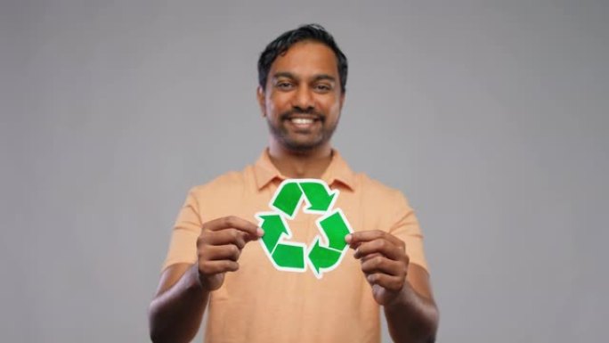 微笑的印度男子手持绿色回收标志