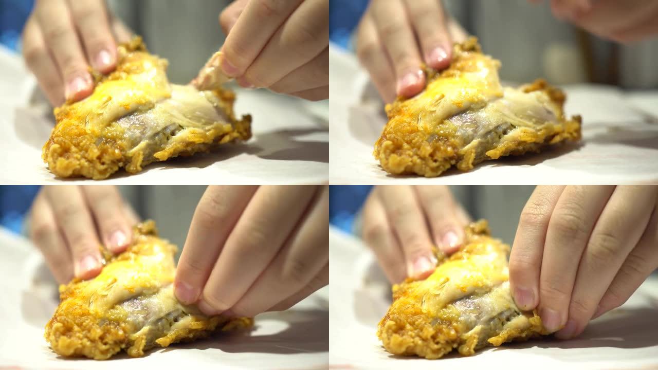 一个小孩在快餐店吃炸鸡。用手剥掉鸡皮。