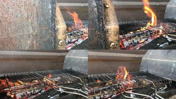 篝火在带有烧肉烧烤架的大型家庭烧烤架上燃烧