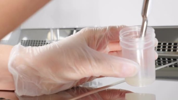 医生处理精液样本的特写。科学家胚胎学家将精子从测试库中分发进行分析。现代微生物学柜的实验室工作人员。