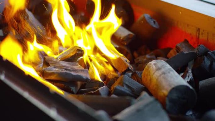 火柴点燃烧烤煤。烧烤架中火煤的特写镜头。当燃烧的火柴落下时，煤开始燃烧。超级慢动作视频