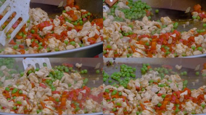 特写镜头: 厨师在巨大的炒锅中烹饪肉块，辣椒，豌豆-慢动作