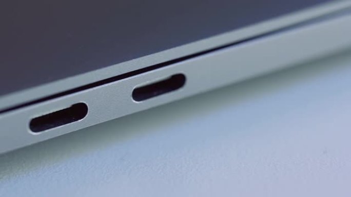 优雅的现代笔记本电脑细节特写。行动。现代技术的概念，计算机的USB端口位于白色平面上。