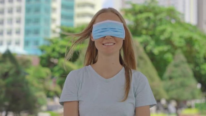 一个年轻女子站在街道上。她以错误的方式戴着医用口罩。她的面具没有遮住她的嘴，而是遮住了她的眼睛。错误