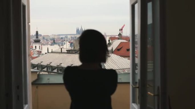女孩的剪影在旅游路线上的电话上拍摄城市全景照片。