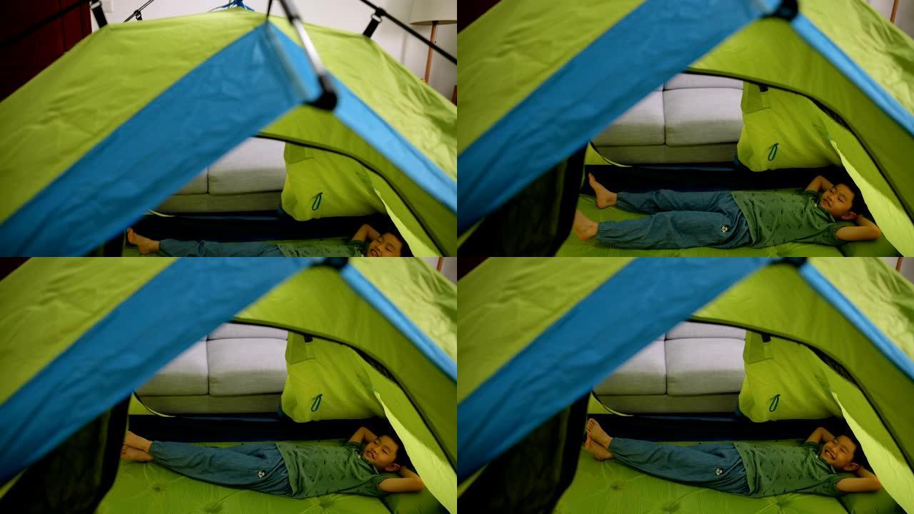 小男孩躺在家里的帐篷里
