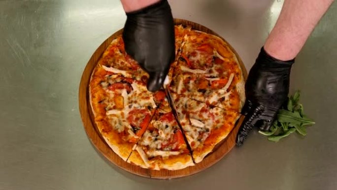厨师在餐厅厨房用圆刀切披萨的特写镜头。