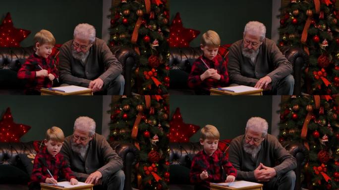 小男孩用毡尖笔画了一幅喜庆的画。祖父和孙子坐在靠近发光圣诞树的装饰房间的沙发上。家庭度假概念。特写。