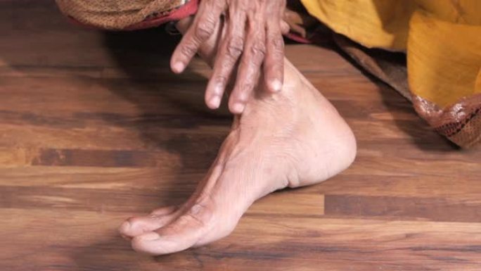 在受伤部位关闭高级女性的脚和手部按摩。