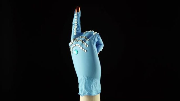 女人手腕手和手指指向符号。交出蓝色医疗装饰手套PPE。一次性手术防护手套中的女性手掌。显示方向的概念