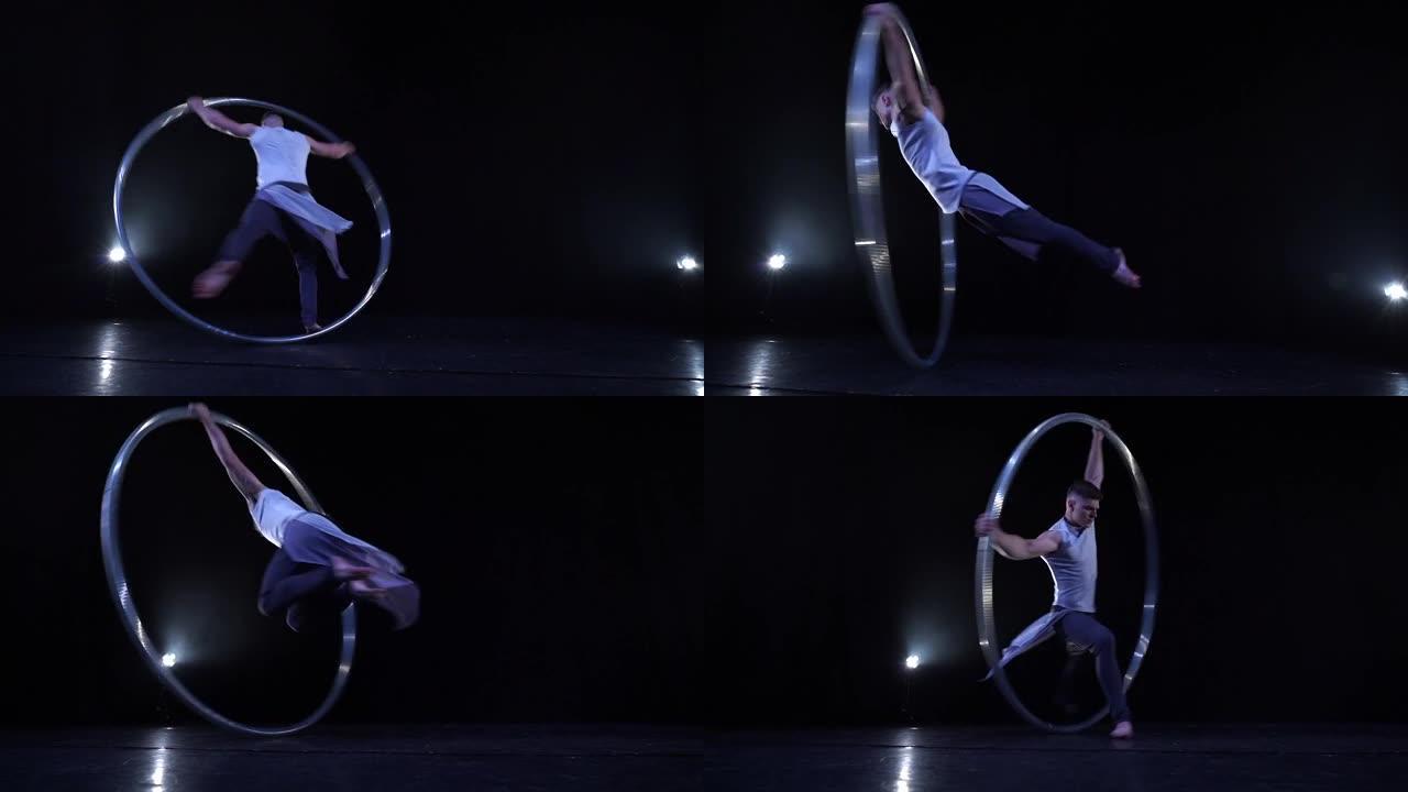 肌肉发达的马戏团艺术家在慢动作的Cyr车轮上旋转。运动、运动和平衡的概念