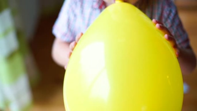 这个孩子给手里的气球充气。球放气了。