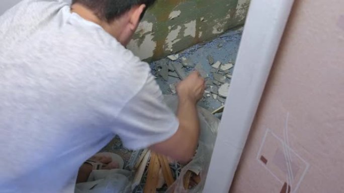 男子在家维修和装修后清理建筑垃圾。