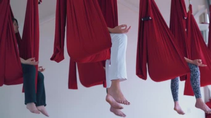 女人光着脚的腿挂在飞行瑜伽吊床上