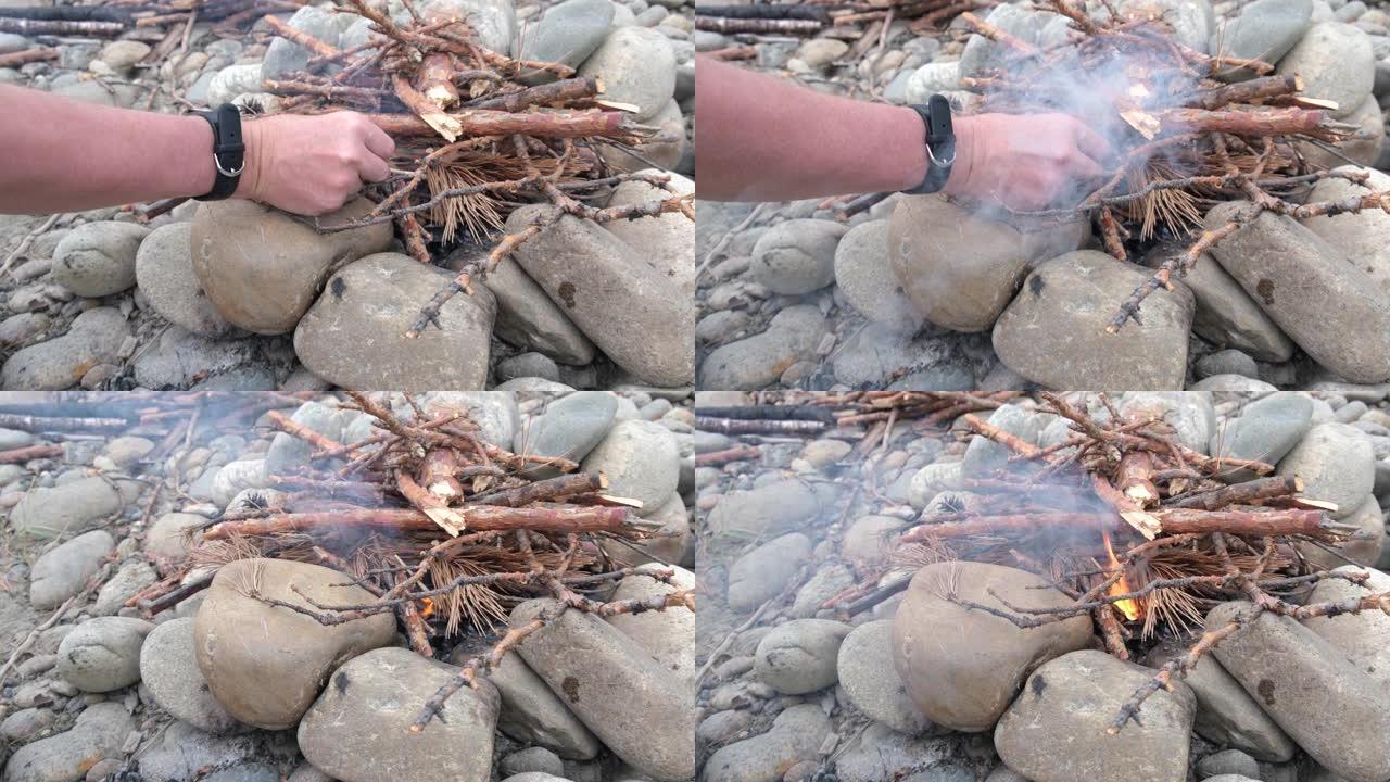 一个人在特殊火柴的帮助下在石头上生火。一个男人的手点燃火的特写镜头。