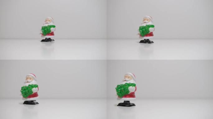 带发条的玩具圣诞老人去白色背景上的圣诞树