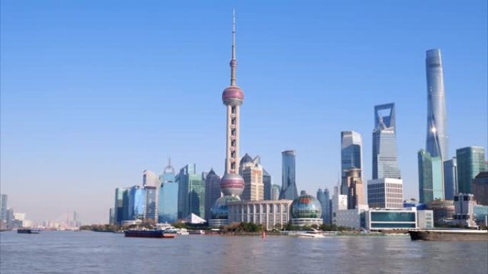美丽的上海城市景观，蓝天背景，在黄浦江上航行的货船，4k慢动作镜头，宽镜头b翻盘拍摄视频。