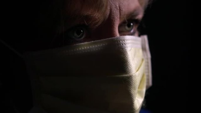 特写黑暗中戴着外科口罩的成熟女人 -- 科罗娜·病毒