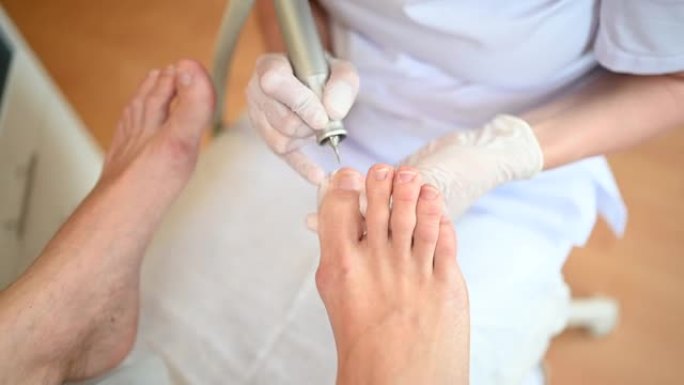 五金医用修脚，带指甲锉钻具。儿科医生修脚治疗的患者。水疗中心用特殊装置进行足部脱皮治疗。足病科的临床