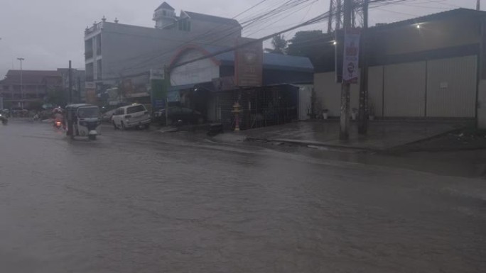晚上下雨时，车辆穿过一条被水淹没的街道