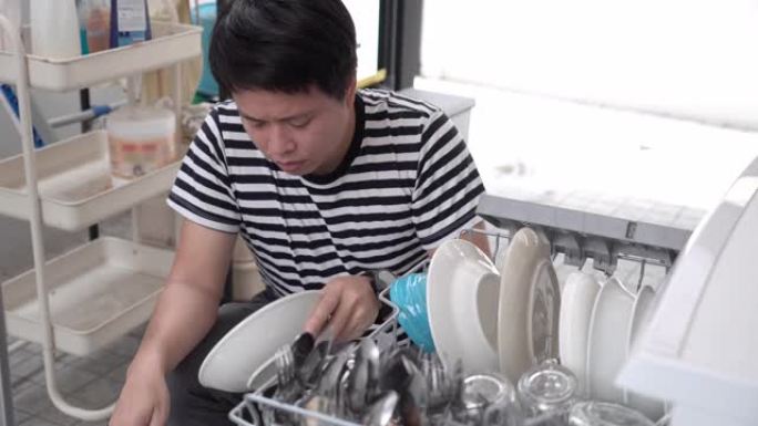 男子从洗碗机中取出干净的盘子。