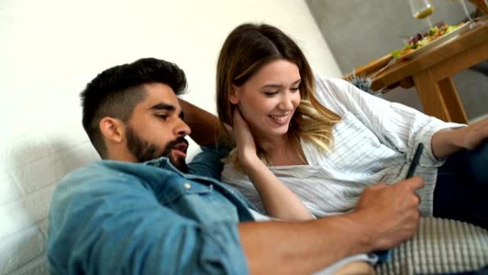 年轻夫妇在客厅放松，浏览社交媒体。