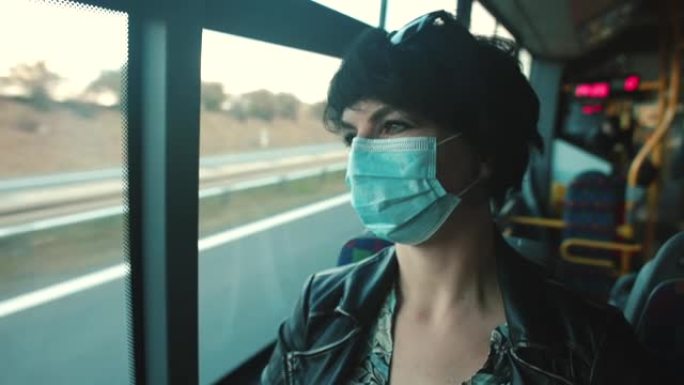 一个戴着面具的女人乘坐公共交通工具新型冠状病毒肺炎。