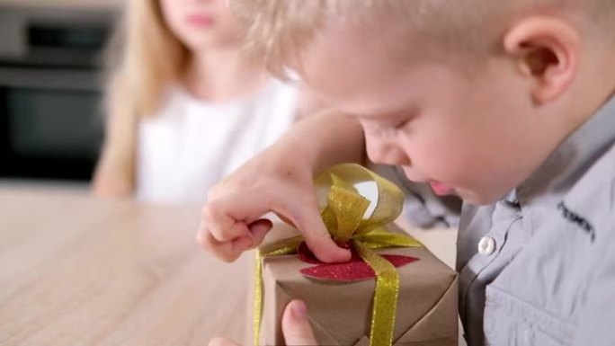 小男孩正准备给他心爱的女孩情人节礼物。儿童装饰大红心礼品盒。慢动作