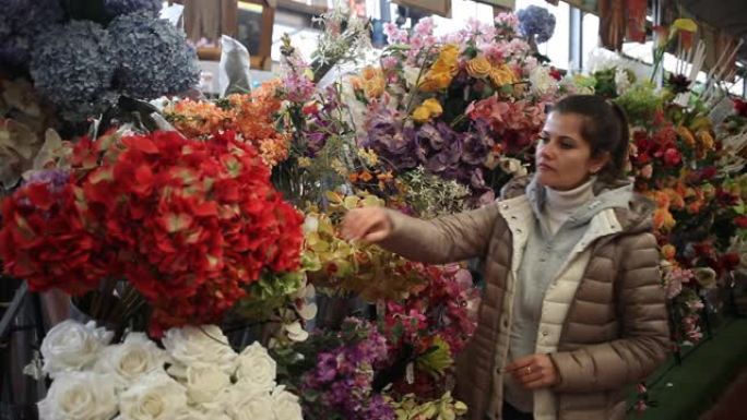 女人在商店里选择人造花