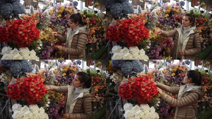 女人在商店里选择人造花
