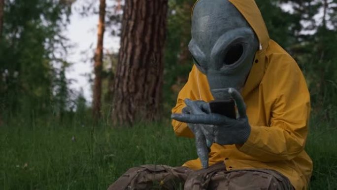 穿着黄色西装的外星人在森林里打电话，飞碟概念，空间