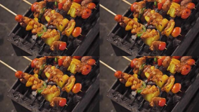 露营地烧烤。肉串上有猪肉、菠萝、番茄和甜椒的食谱。