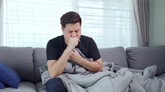 4k亚洲年轻人患流感并在家中沙发上感到不适的录像