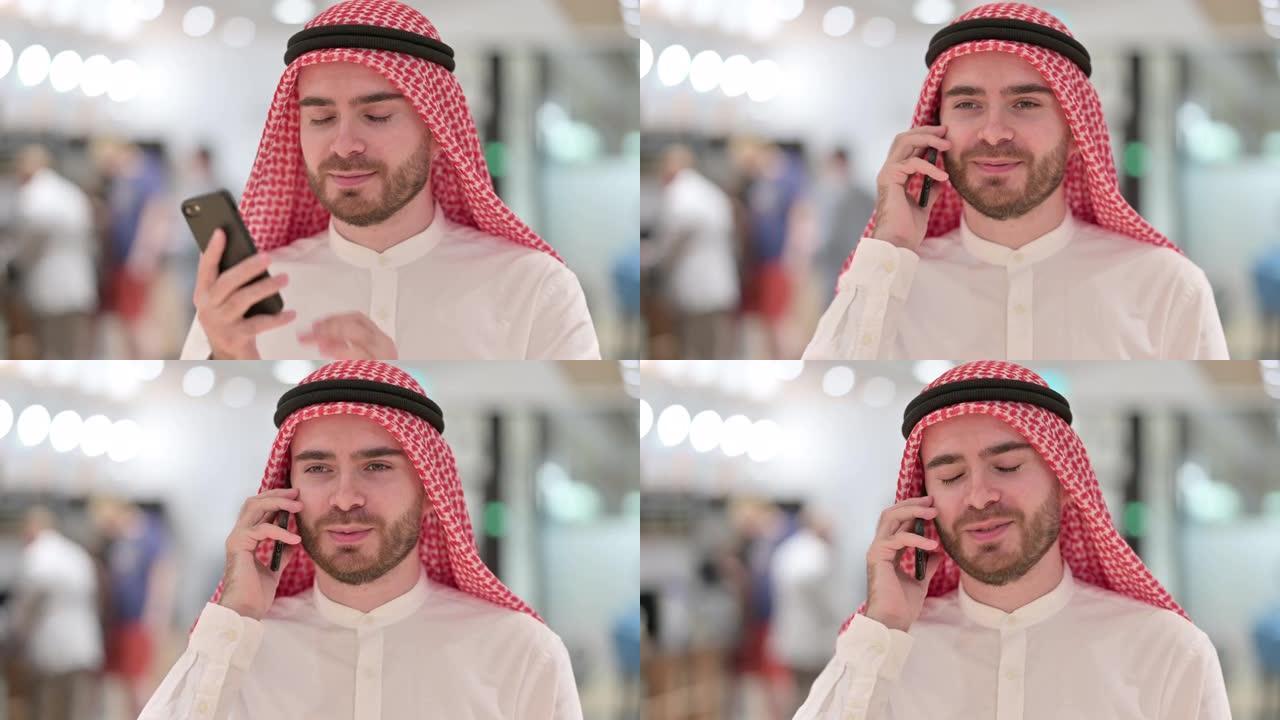 快乐的阿拉伯商人在智能手机上聊天的肖像