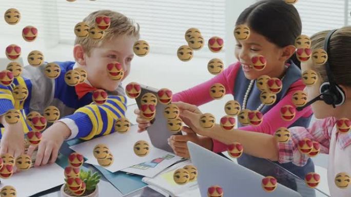 使用数字平板电脑漂浮在一群孩子身上的多面表情符号