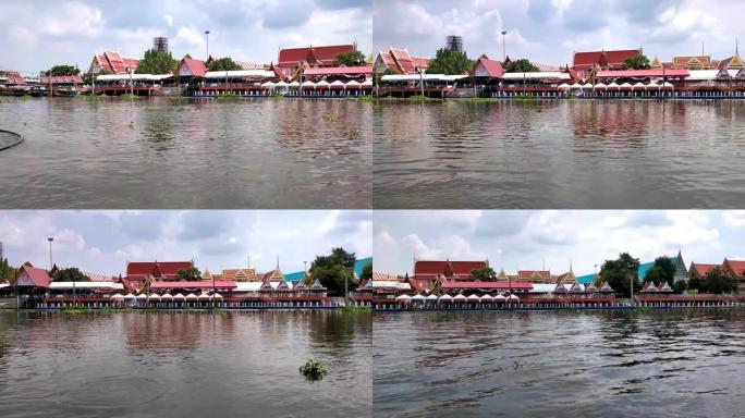 泰国沿河寺庙旁边的水上市场。