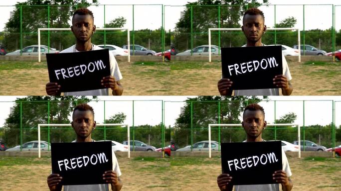 非洲青年抗议者手持纸板“自由”