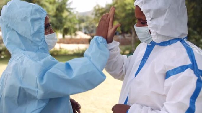 两名穿着PPE服的女医生精疲力尽，帮助邦德彼此分享