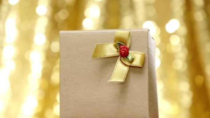 带有圣诞灯背景的棕色礼品盒。