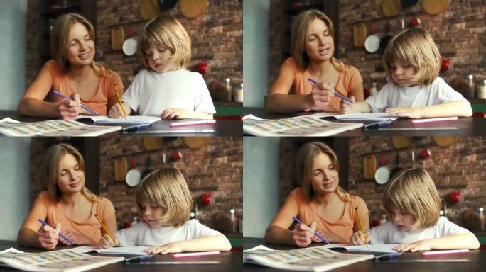 妈妈帮她的小男孩在学校字帖里做作业。她解释课程，坐在厨房里的桌子旁，室内时尚。慢动作