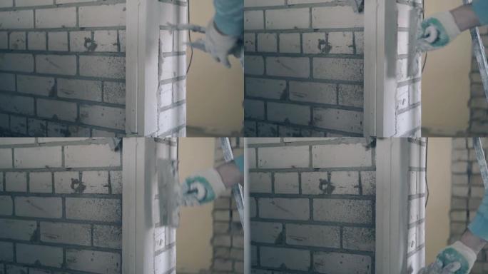 男人用手将石膏石膏板线固定在砖墙上