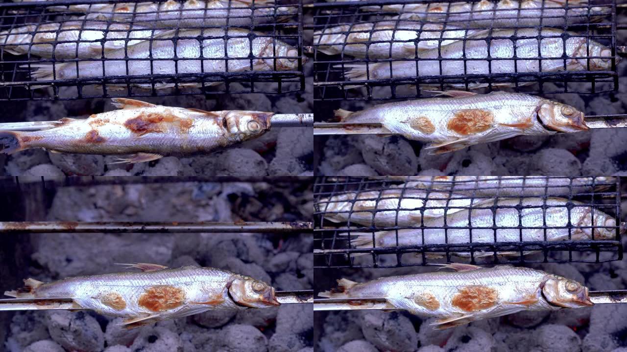 在煤上烤的Coregonus sardinella。鱼在煤上油炸。烧烤。油炸时将鱼翻过来，形成美味的