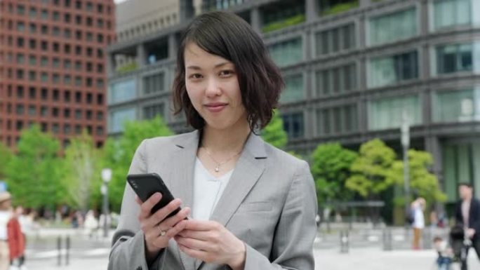 日本女商人在旅途中使用智能手机